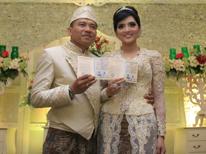 Duet penyanyi Anang Hermansyah dan Ashanty memperlihatkan buku nikah seusai akad pernikahahnya di Masjid Al bina, Jakarta, Sabtu, (12/5)