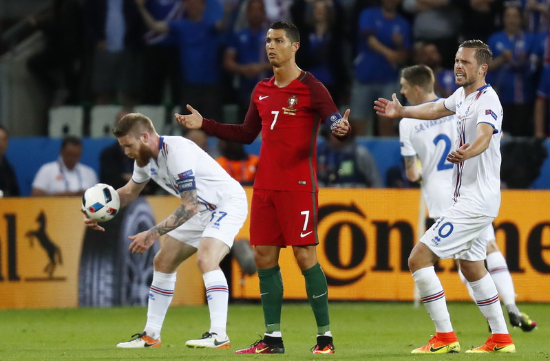 Football Soccer - Portugal v Iceland - EURO 2016 - Group F - Stade Geoffroy-Guichard, Saint-Étienne, France - 14/6/16 Portugal's Cristiano Ronaldo reacts as Iceland's Gylfi Sigurdsson and Aron Gunnarsson look on REUTERS/Kai Pfaffenbach Livepic